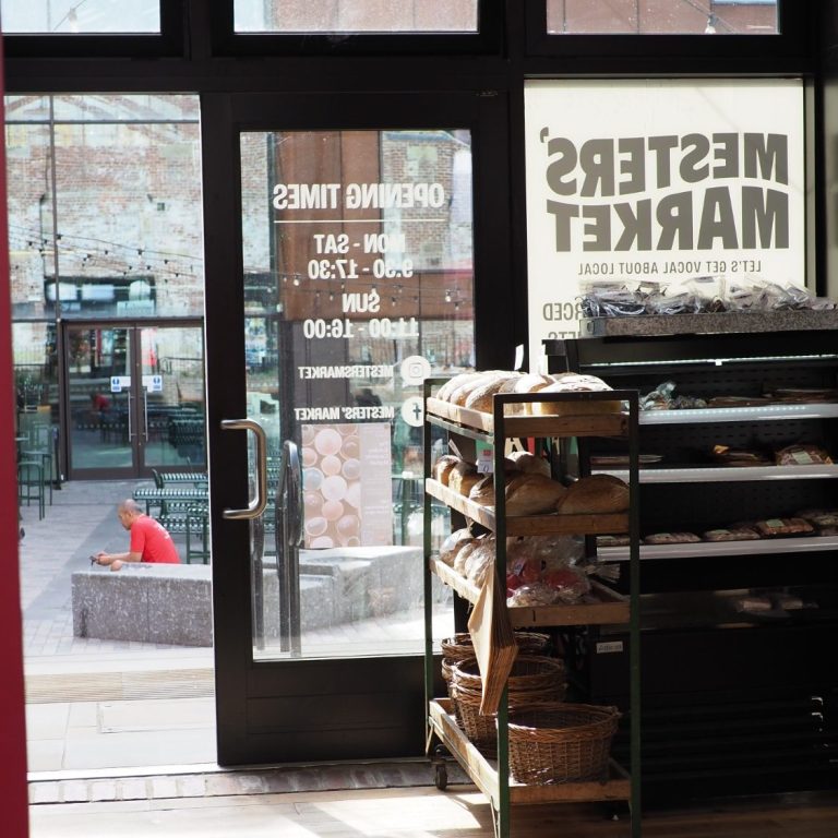 Bright bedroom featuring two single beds, a dresser, and a window with soft furnishings.