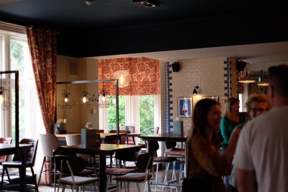 A modern café interior with people chatting and stylish décor.