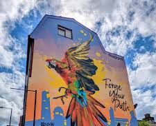Cozy bedroom with two beds, soft blankets, a bedside table, and natural light from the window.