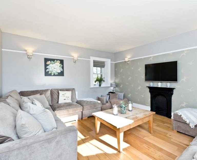 Retreat and Spanish Bright living room with grey walls, a comfortable sofa, coffee table, and a TV.