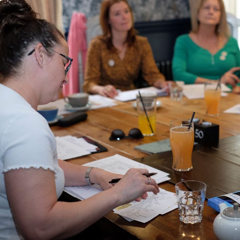 A diverse group of people smiling and engaged in conversation.